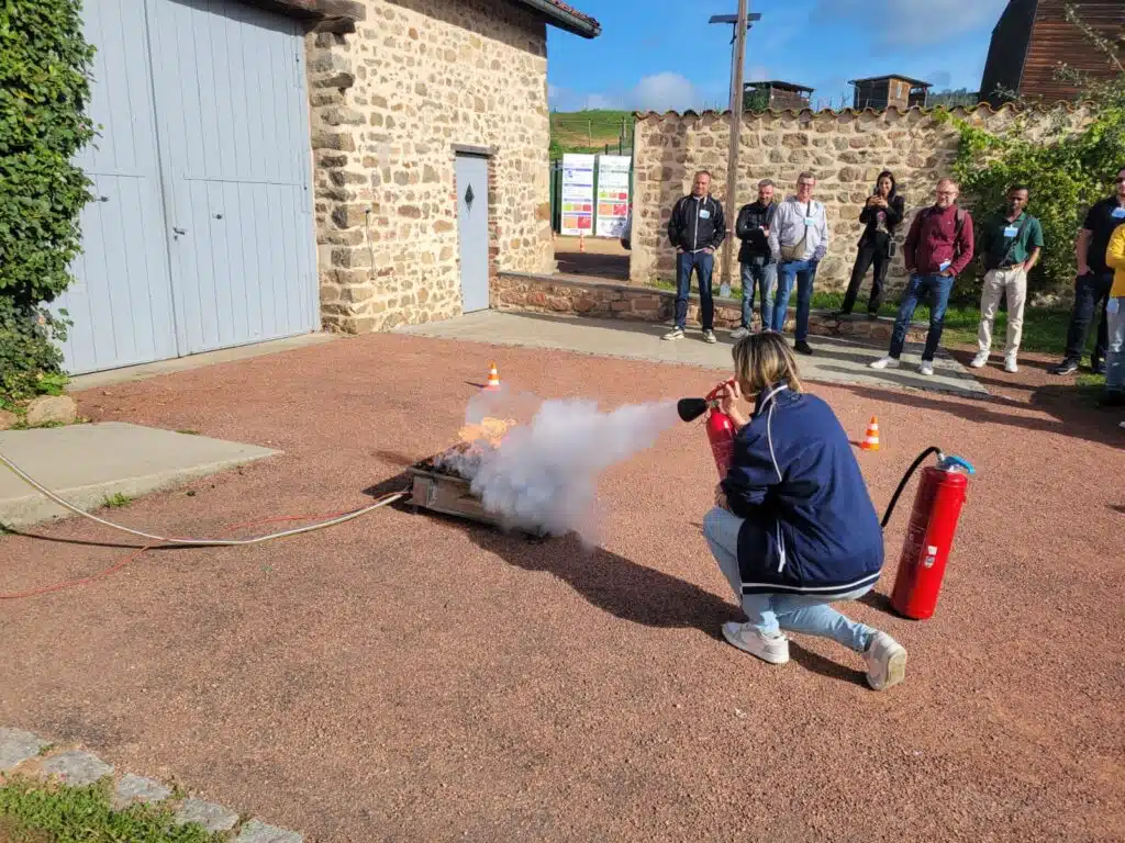 Stagiaire en train de manipuler un extincteur lors d’un exercice pratique en extérieur
