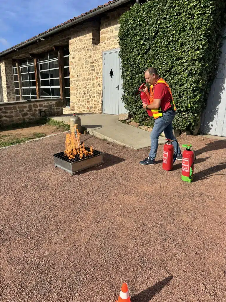 Formateur réalisant une démonstration de l’utilisation d’un extincteur lors d’un exercice pratique