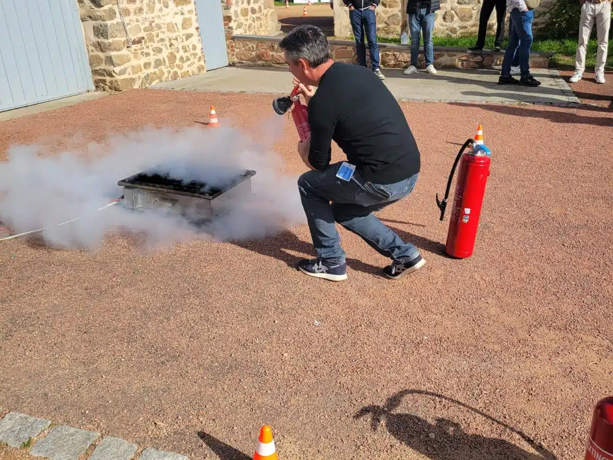 Participant éteignant un feu au CO2 sur bac à feu pendant un Safety Day